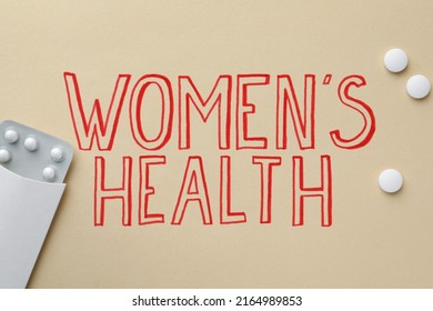 Words Women's Health And Pills On Beige Background, Flat Lay