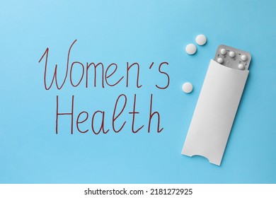 Words Women's Health And Pills On Light Blue Background, Flat Lay