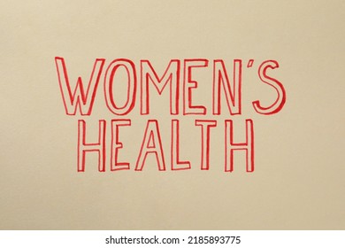 Words Women's Health Written On Beige Background, Top View