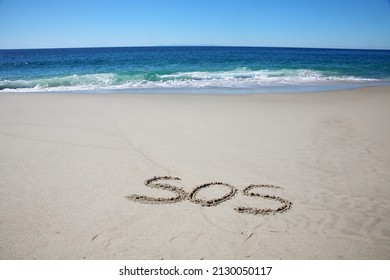 Words written in sand. The Initials S. O. S. written in the sand on the beach with the ocean background. S. O. S. are initials for the distress message Save Our Ship. Help. SOS. Save Our Ship. .   - Shutterstock ID 2130050117