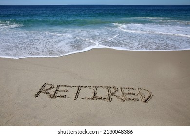 Words written in sand. The word RETIRED written in the sand on the beach with the ocean in the background. When retired you have more time to enjoy the beach and ocean. Relax you are Retired. Retired.