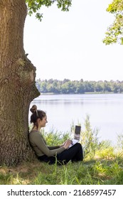 Work from anywhere. Remote freelancer work in nature. Young woman, female freelancer working with laptop with Beautiful view of forest and lake. freelancer paradise, freedom of teleworking. distance - Shutterstock ID 2168597457