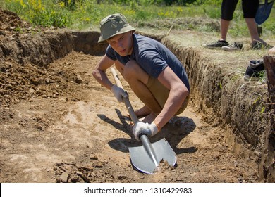 The work of an archaeologist in July 2018, in Verkhniy Saltov, Ukraine. Archaeologist guy cleans excavation