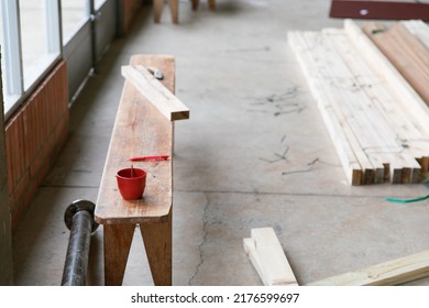 A Work Bench At A Construction Site With A Cup Of Coffee And Planks Of Wood. 