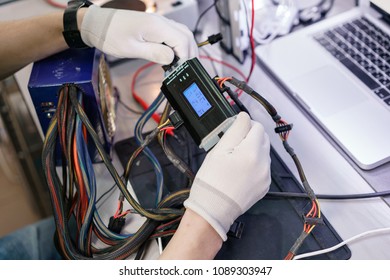 Work With A The Computer's Power Supply. Microelectronics Device. Close-up Hands Of A Service Worker Repairing Modern PC. Repair And Service Concept.