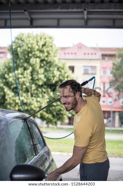 Work is done\
with a smile. Man washing his\
car.