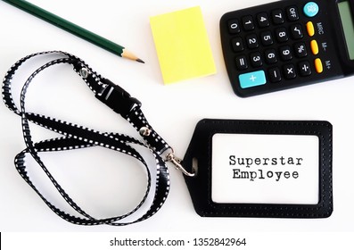 Work Equipment On Desk- Pencil /calculator/yellow Note Pad/ Staff ID Card  With Written Message SUPERSTAR EMPLOYEE, All On White Background. Concept Of An Excellent Or Outstanding Talented Employee