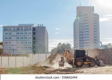 Work of excavating machine on building construction site.