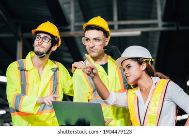 Work At Factory. Workers Man And Engineer Woman Team Working Together In Safety Work Wear With White And Yellow Helmet Using Laptop Computer.professional Women Engineer Pointing In Factory Meeting