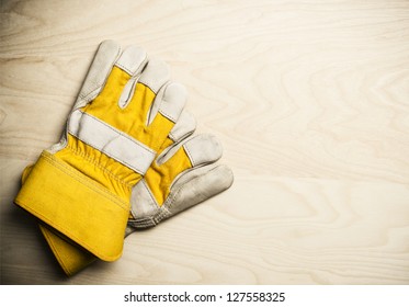 Work gloves on a wooden background.