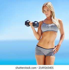 Work Hard, Look Great. Portrait Of A Beautiful Young Woman Lifting Weights Outside.