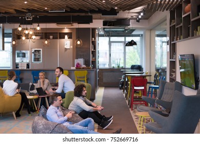 Work Hard Play Hard. Workers Playing Computer Games In Creative Startup Office