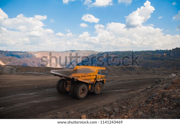 The work of a heavy quarry dump truck in the\
iron ore quarry.	
