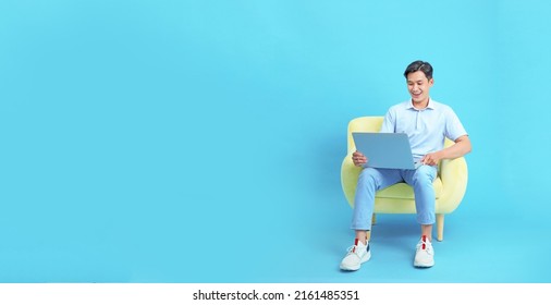 Work from home concept with an Asian young handsome guy, with laptop computer, isolated on blue background - Powered by Shutterstock