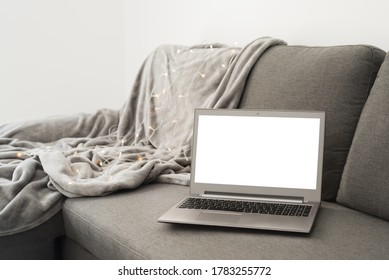 Work From Home Concept: Laptop Computer With Blank White Screen On Gray Sofa Bed