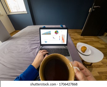 Work from home concept. POV view of a drinking coffee in bed with a laptop. - Powered by Shutterstock