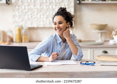 Work From Home. Happy Freelancer Woman Working On Laptop In Kitchen Interior, Positive Lady Sitting At Table With Computer And Taking Notes, Enjoying Remote Job Opportunities