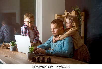 Work from home. Man works on laptop with children playing around. Family together
