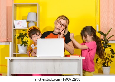 Work from home. Mother work on laptop with children playing around. Children make noise and disturb mom at work. 