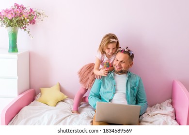 Work From Home. Stress To Work With Family Around. Parent At Home Office Because Of Covid 19. Fathers Day With Daughter In Pink Room. Cute Girl Putting On Make Up On Her Father.