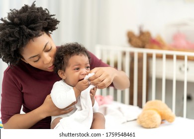 Work At Home Together African American Single Mom Raising Children Of African Baby. Beautiful Mother With Upset Face Holds Crying Infant On Bed In White Bedroom.