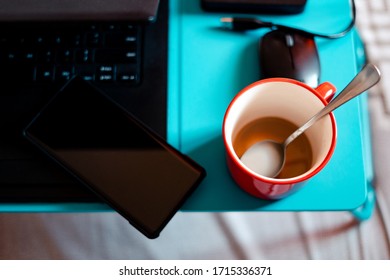 Work From Home Workspace Set-up During Coronavirus Pandemic. Red Mug, Laptop,portable Hard Disk And Lap Desk.