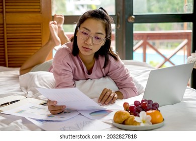 Work From Home, A Young Asian Woman Who Works In Finance At Home Calculates Financial Graphs Showing The Results Of His Investments, Planning The Steps Of His Business Growth.