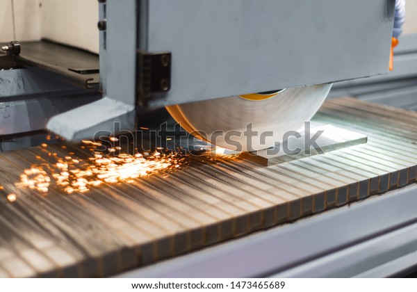 Work\
of an industrial surface grinding machine. Grinding of a flat metal\
part. Sparks fly out from under the grinding\
wheel.