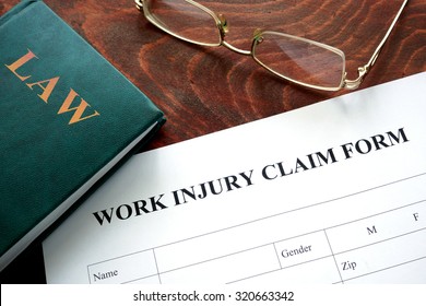 Work injury claim form on a wooden table.