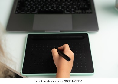 work at a laptop and a graphics tablet. 