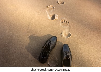 Work Life Balance Concept, Businessman Take Off His Working Oxford Shoes And Leave It On The Sand Beach For Walk Into The Sea On Sunny Day. Top View