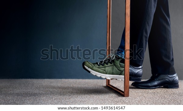 Work Life\
Balance Concept. Challenging to Change. Low Section of Businessman\
Steps passing a wooden frame. Half is a Formal Dress and other side\
is a Casual Traveling Shoes\
