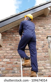 Work Man Climbing A Ladder At The Side Of A House