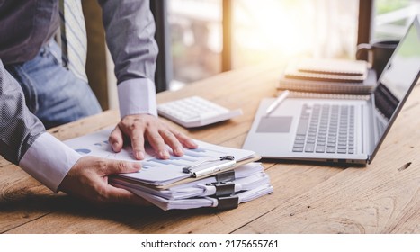 work from office A businessman works a bunch of paper files to find information on his desk at home. business report pile of unfinished documents - Shutterstock ID 2175655761