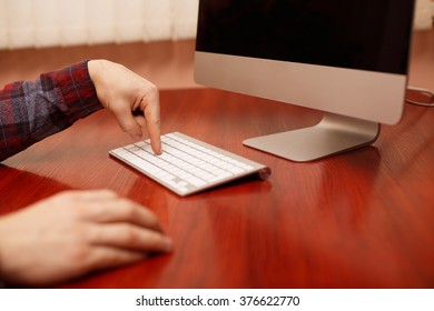 work in office at computer. mockup work on PC. Push button. Side view of the computer is on the work table in a Home office. freelancer man working with computer