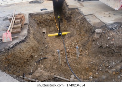 Work on the installation of engineering and heating systems. Two plastic pipes one yellow for gas pipe and one black for power lines. They are in a sand ditch.