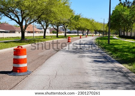 Work on road. Construction cone. Traffic cone, with white and orange stripes on asphalt. Street and traffic signs for signaling. Road maintenance, under construction sign and traffic cone on road