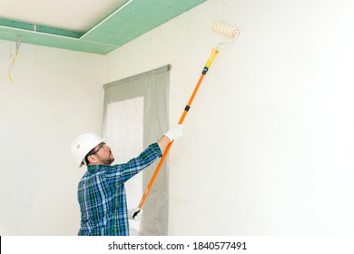 Work painter paints the wall with a roller