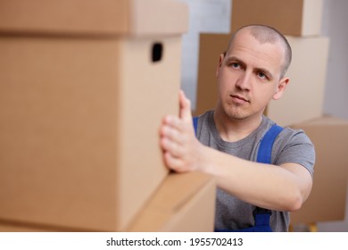 Work People Concept - Worker In Uniform Holding Big Box In Warehouse