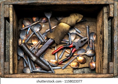 Work in process of handmade broze cutlery of spoons, forks, with iron hammer and pliers in wooden box in bronze cutlery factory, image for industrial background - Powered by Shutterstock