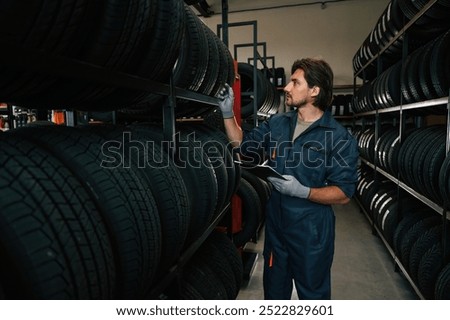 Work in progress, manager is in warehouse. Man is in the tire fitting car service.