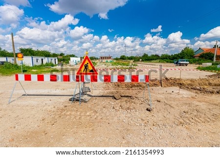 Work in progress, triangle sign with boundary, caution symbol, trench is on construction site. 