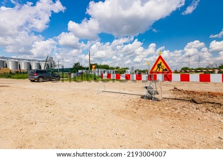 Work in progress, triangle sign with boundary, caution symbol, trench is on construction site. 