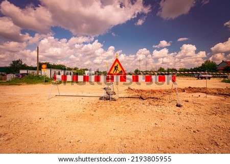 Work in progress, triangle sign with boundary, caution symbol, trench is on construction site. 
