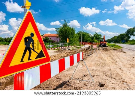 Work in progress, triangle sign with boundary, caution symbol, trench is on construction site. 