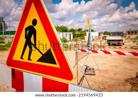 Work in progress, triangle sign with boundary, caution symbol, trench is on construction site. 