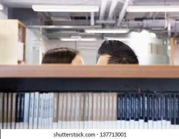 Work Romance Between Two Business People Hiding Behind Shelves