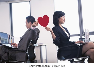 Work Romance Between Two Business People Holding A Heart