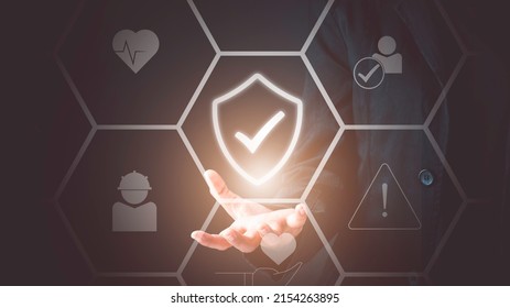 Work safety concept. Businessman holding check mark in shield icon. Safety first sign on virtual screen. Hazards, protections, regulations and insurance, Zero accidents.
 - Shutterstock ID 2154263895