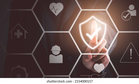 Work safety concept. Businessman touching check mark in shield icon. Safety first sign on virtual screen. Hazards, protections, regulations and insurance, Zero accidents. - Powered by Shutterstock